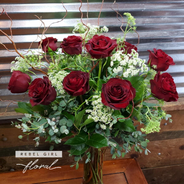 One Dozen Red Pearl Roses arranged in a glass vase