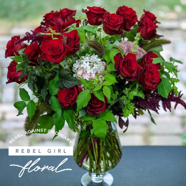 Beautiful bouquet of red roses with unique greens and accents arranged by Rebel Girl Floral