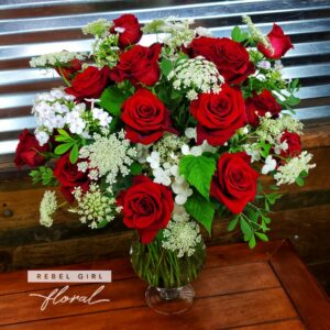 One Dozen Red Pearl Roses arranged in a glass vase